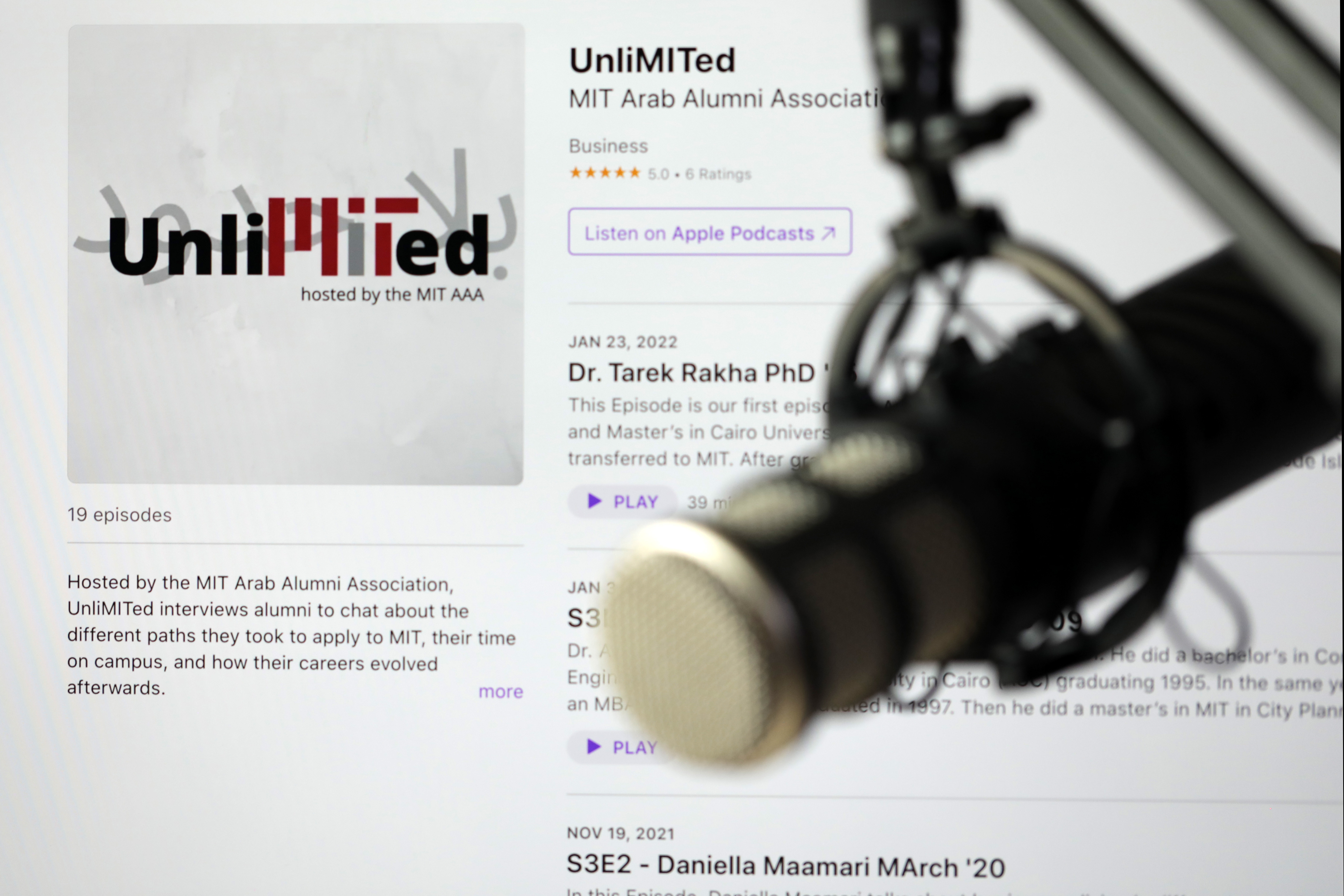 A microphone in front of a screen that displays the UnliMITed podcast web page