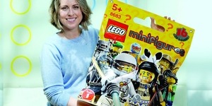 Tara Wike ’97, design lead for Lego Minifigures, holds an oversized product replica.