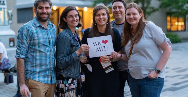 Image: Four alumni outdoors at Tech Reunions holding a sign that reads We Heart Tech Reunions!