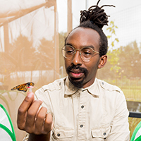 A photo of D. André Green II holding a monarch butterfly