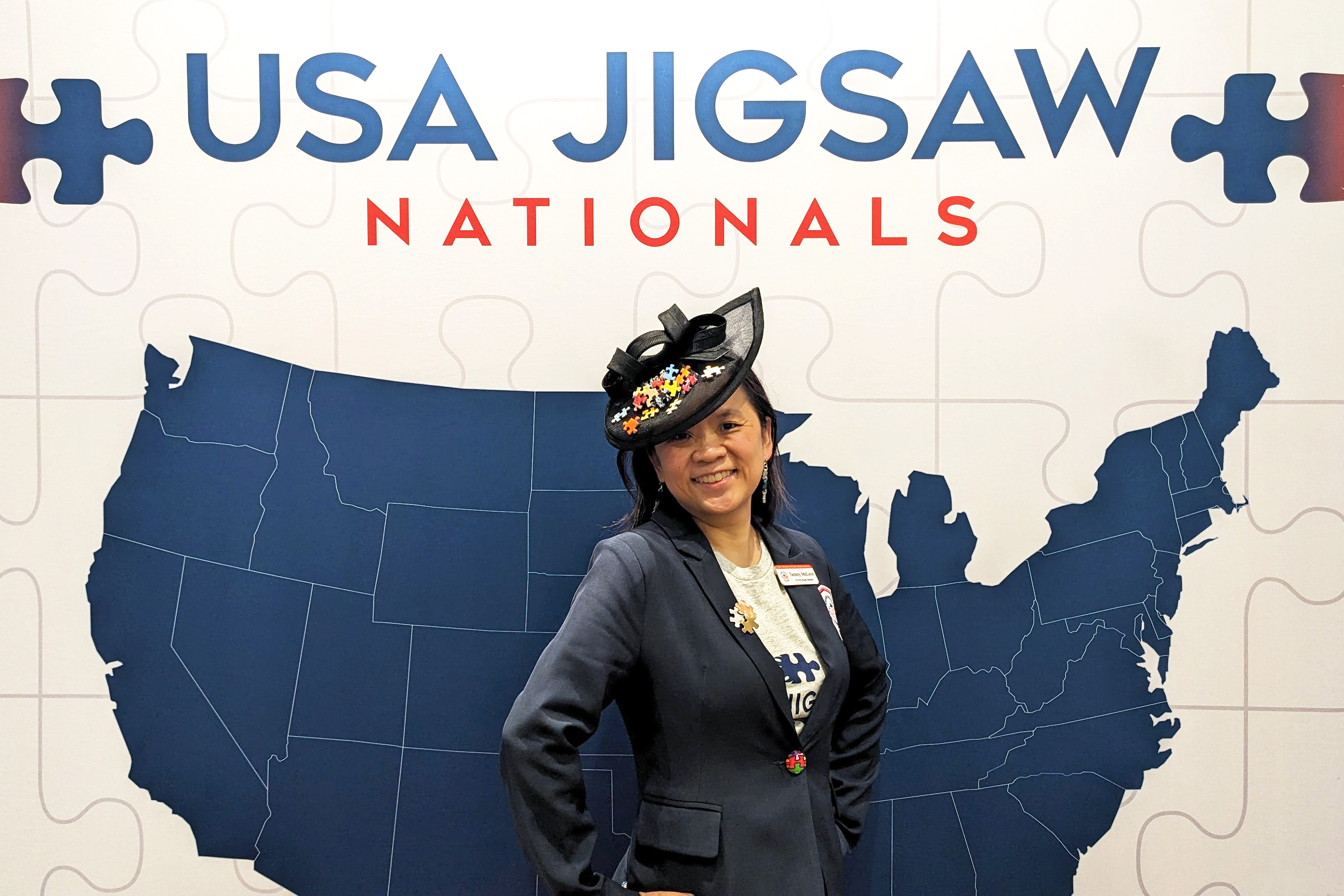 A photo of Tammy McLeod standing in front of a sign with the outline of the USA