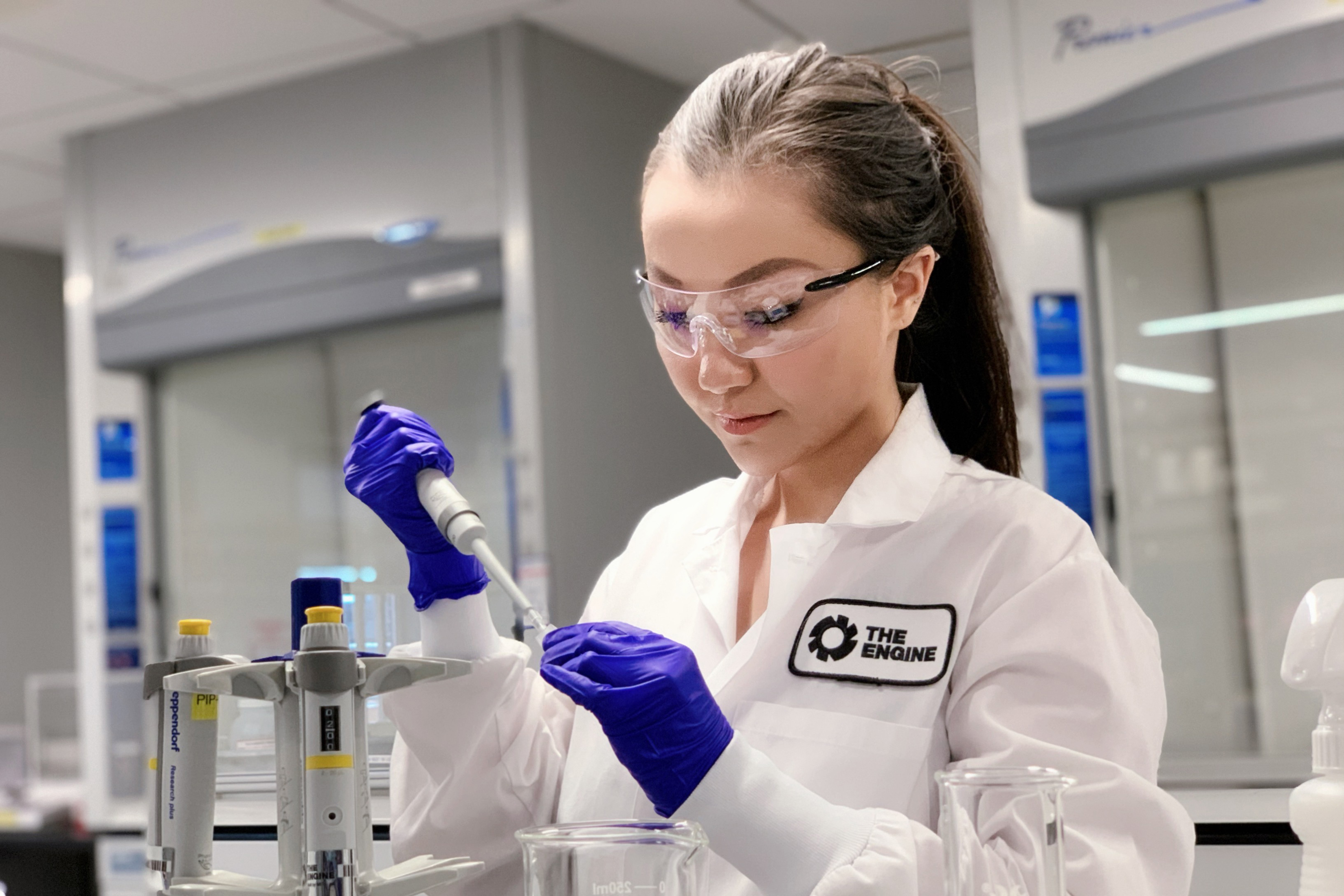 A photo of Sophie Bai in a lab holding lab equipment 