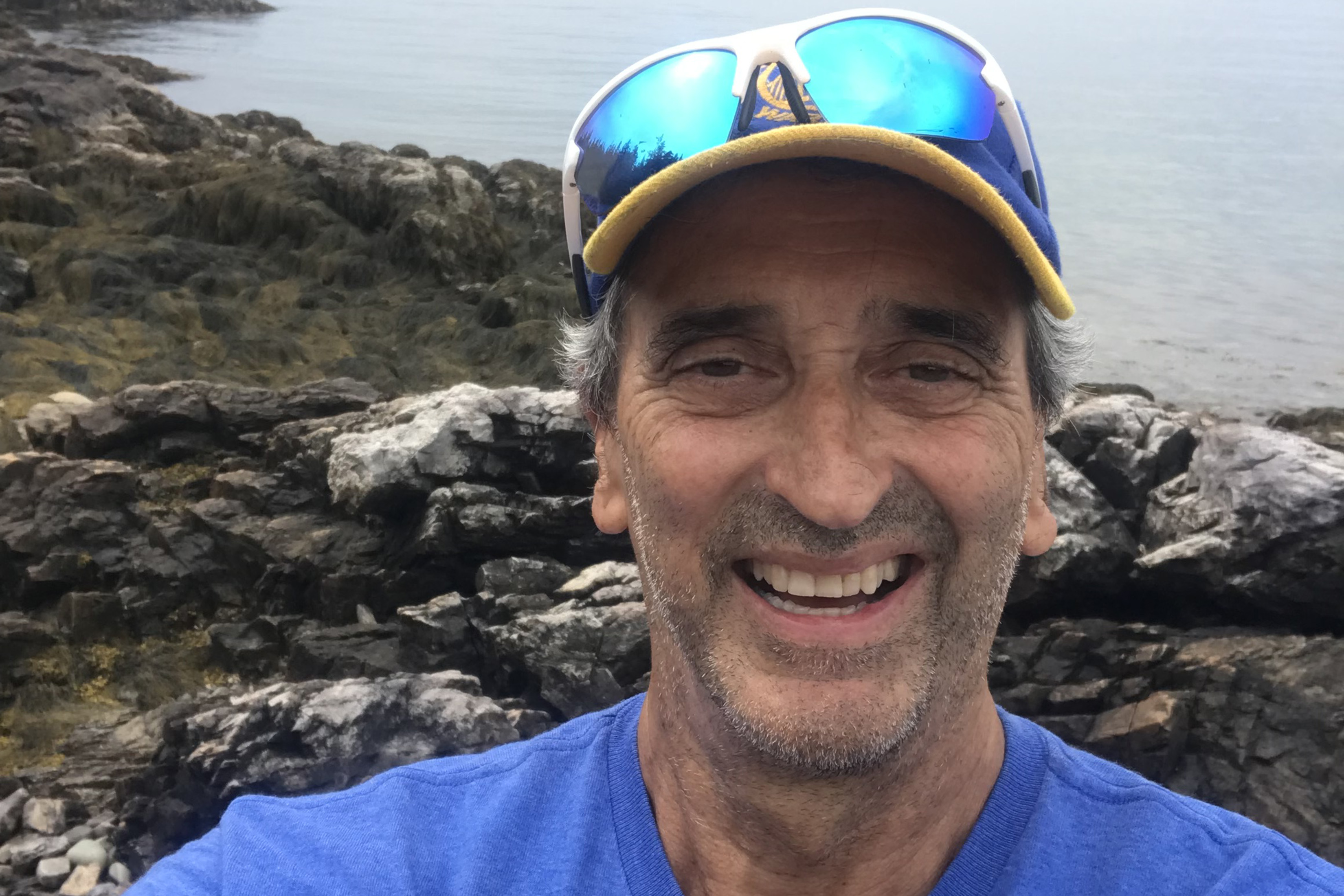 A photo of Paul Josephson with rocks and the ocean behind him