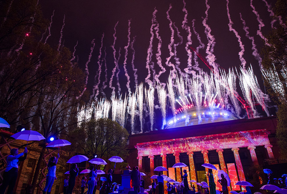 Fireworks go off as dancers with umbrellas perform in Killian Court.