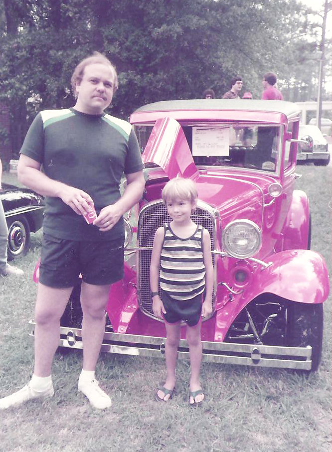 David Lucsko as a child with his dad standing in front of a red vintage car