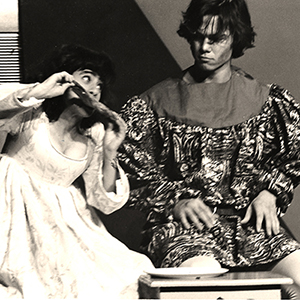A photo of Jo A. Ivester and Jon Ivester wearing costumes on a stage during a play