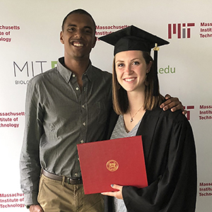 A photo of Carrington Motley ’16 and Haley Strouf Motley ’18 wearing a gap and cown and holding a diploma