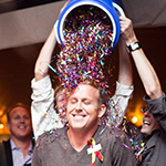 A photo of MIT alum Chris Schell with a bucket of confetti being dumped on his head