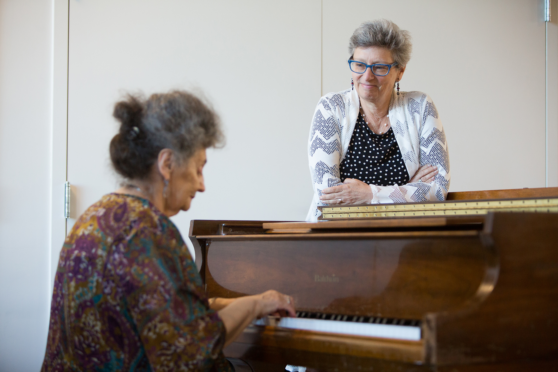 At 2Life Communities, Amy Schectman watches Tatyana Faynberg playing the piano