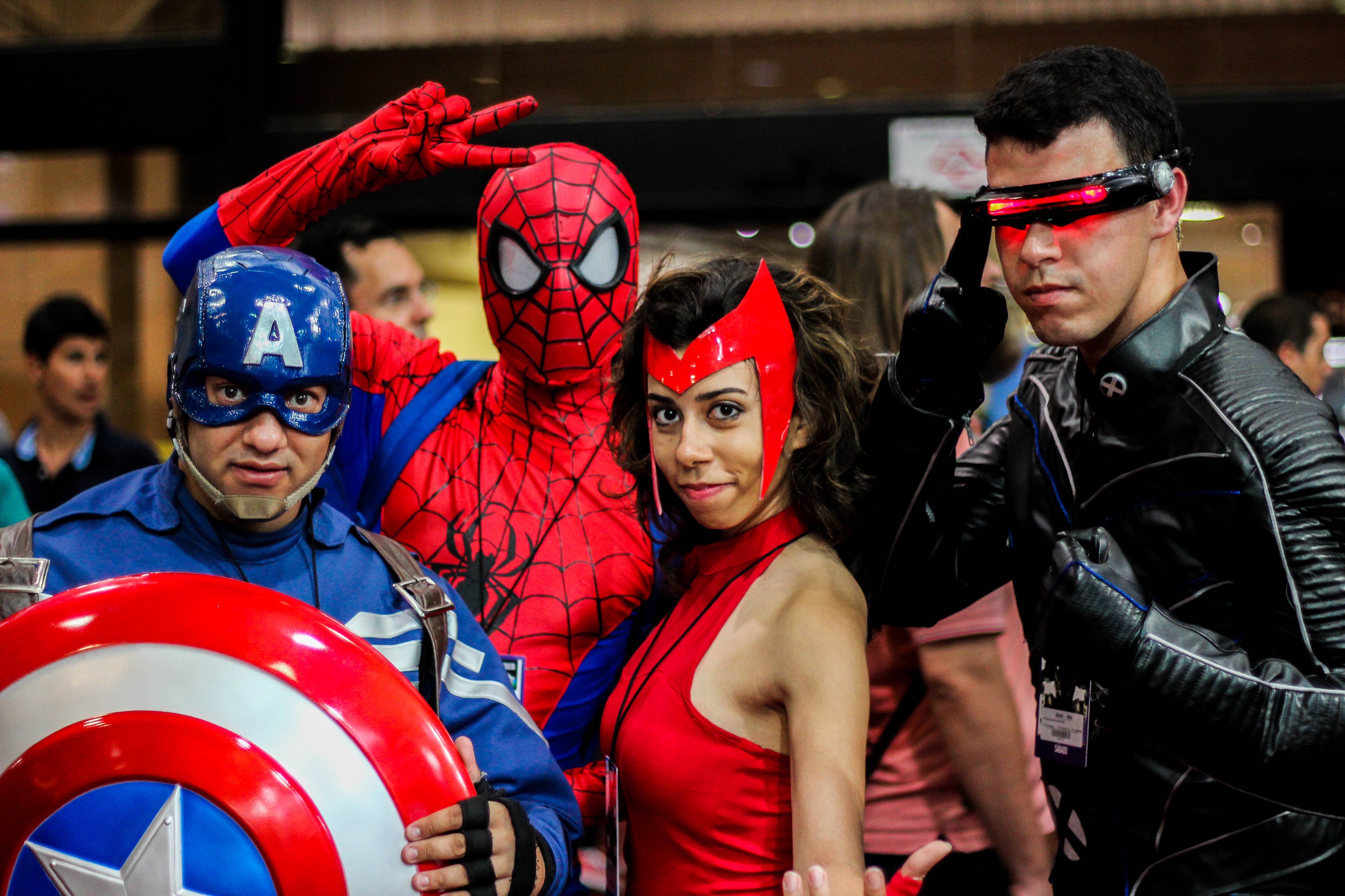 Four people pose in Marvel superhero costumes