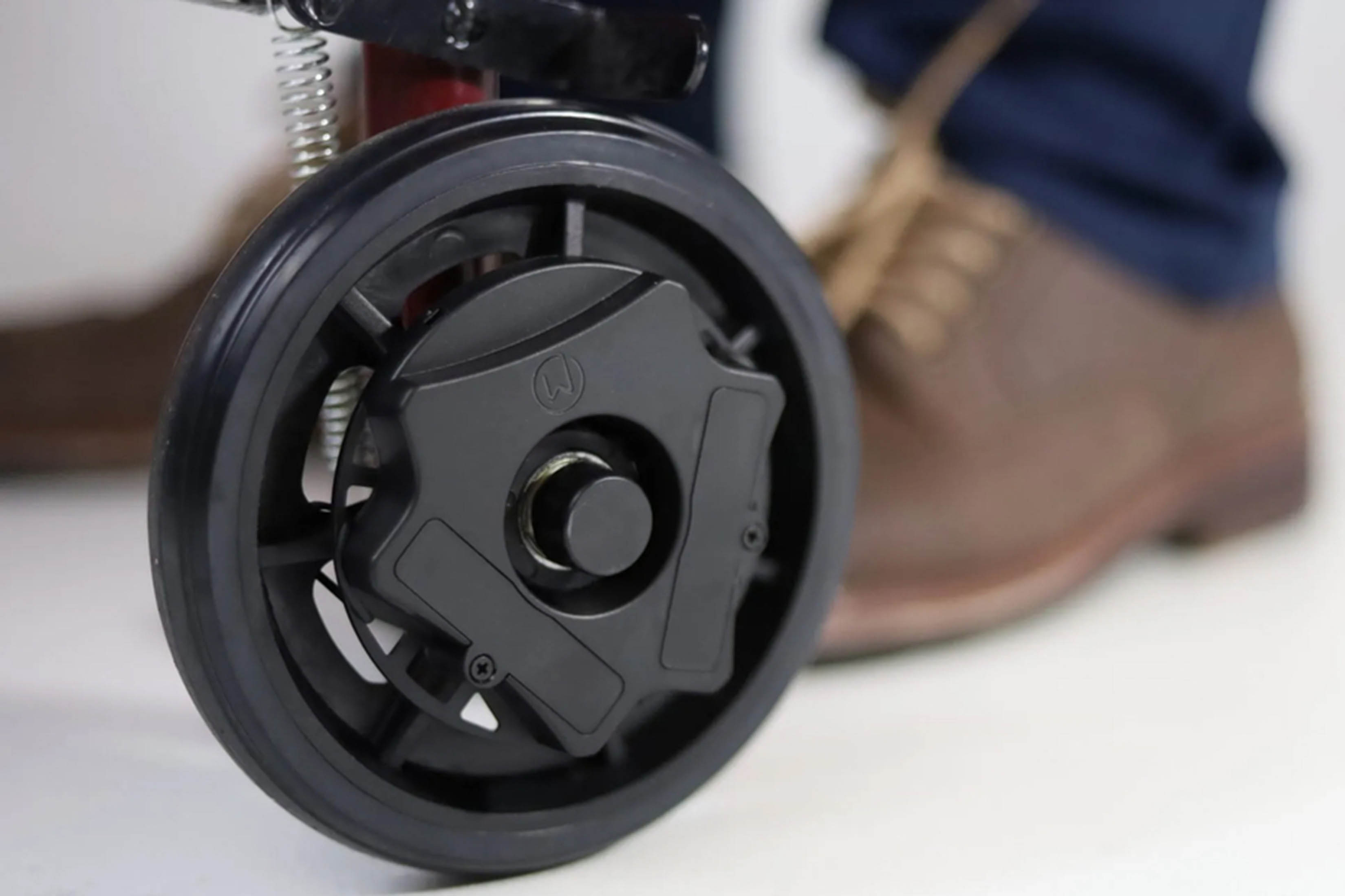 Closeup of WalkWise device, black circular attachment to a wheel