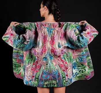 A woman, photographed from behind, dons a multicolor kimono showing intricate designs and embroidery 3D printed on the fabric.