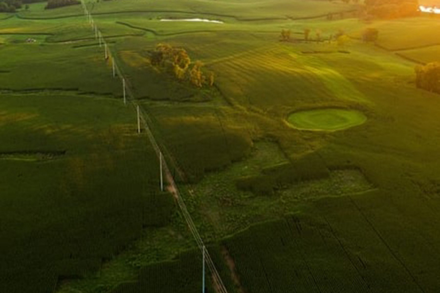 Aerial shot of powerlines and grass fields.