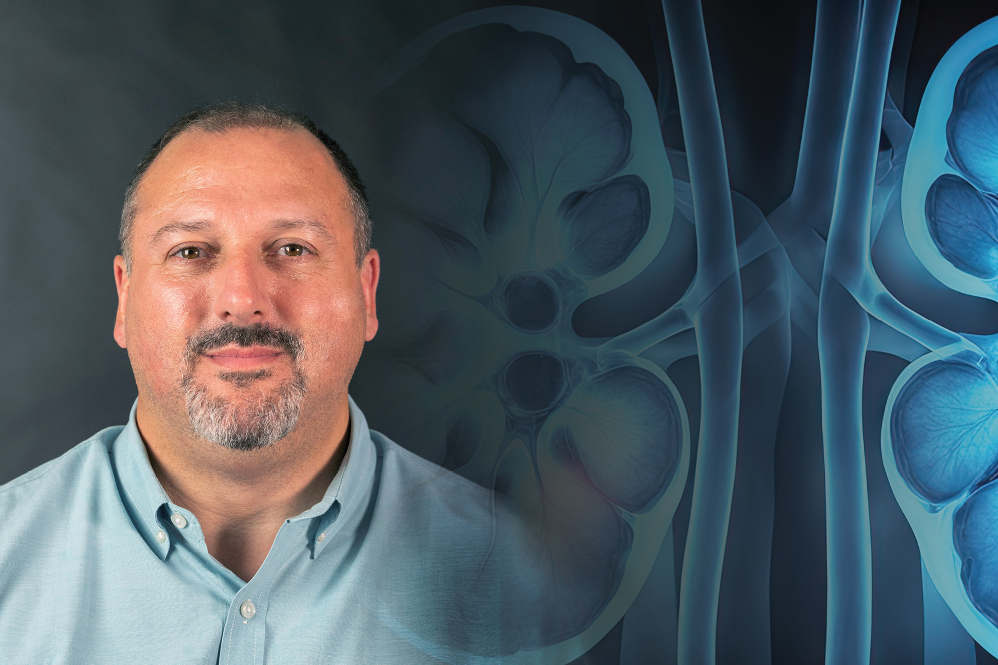 Headshot of Dr. Reynold I. Lopez-Soler over a blue background illustration of kidneys.