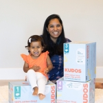 Photo of Amrita Saigal and child posing with boxes of diapers