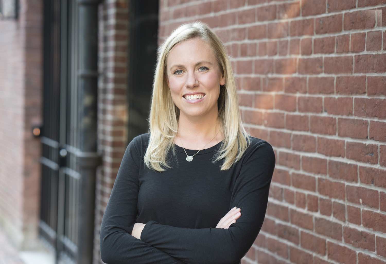 MIT alumna Kate Cincotta standing outside in front of a brick wall