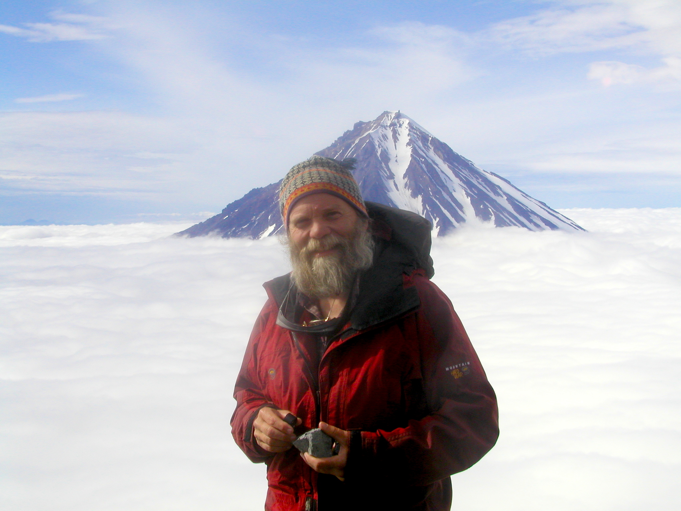 John Eichelberger with a volcano rising through the clouds behind him.