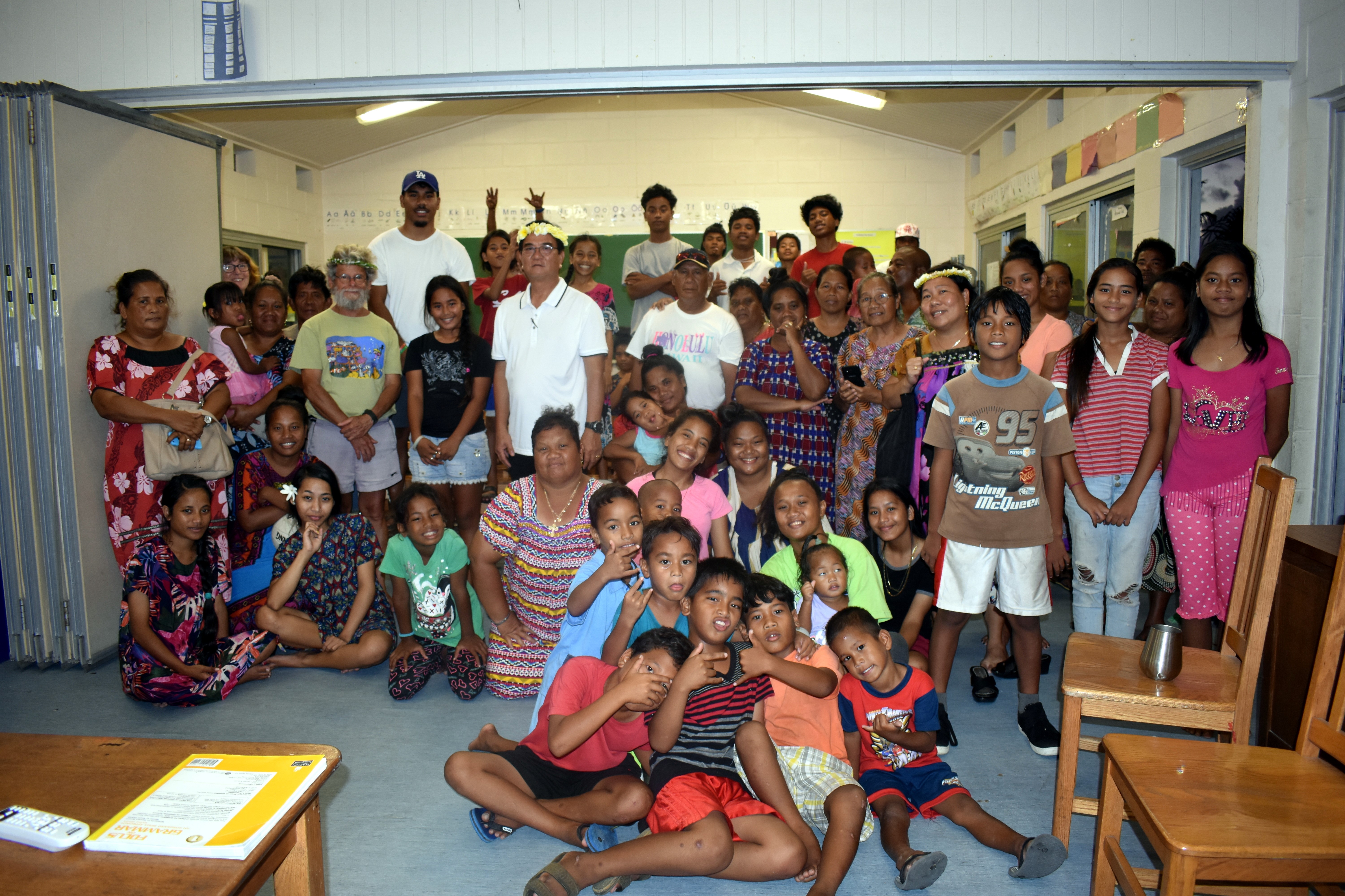 Several adults and children pose for an indoor group shot