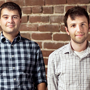Vacarious surgical cofounders standing in front of a brick wall