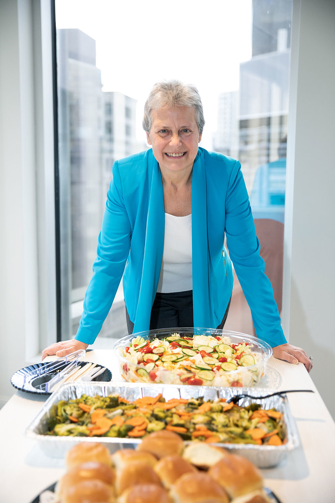 woman standing at head of table with catered food