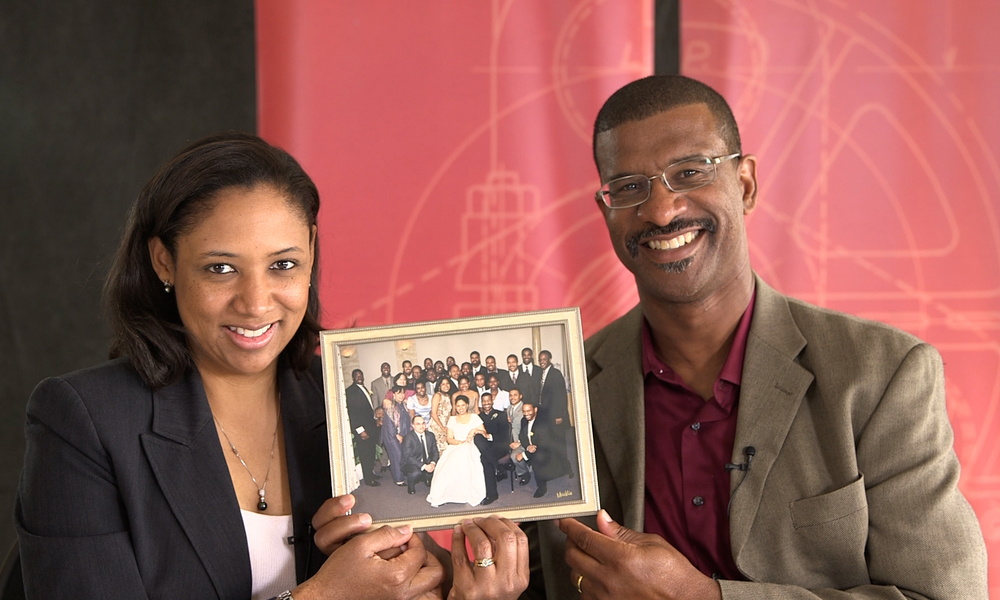 MIT alumni couple holding their wedding photo