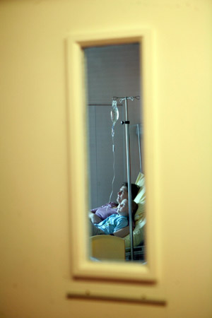 A mother and her ill son watch TV together at Hospital St. Louis, Paris. The child is in a section for children with blood diseases, sometimes cancer. (© Owen Franken).