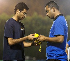 Grad students Srinivasan Jagannathan, left, and Ankur Sinha check the taped tennis balls in preparation for a cricket match at MIT. Tech Photo: Noah Spies.