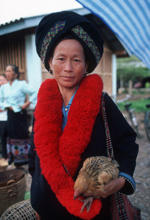 Yao tribe woman with her chicken at a market in northern Laos (© Owen Franken).