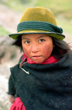 An Ecuadorian girl wears a green hat and poncho to protect against the cold, July 1995 (© Owen Franken/CORBIS).