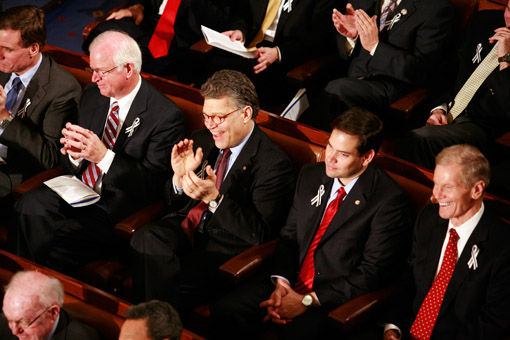 Senator Al Franken (D-MN) watches the 2011 State of the Union speech by President Obama. He's seated between conservatives Saxby Chambliss (R-GA), left, and Mario Rubio (R-FL) (© Owen Franken).