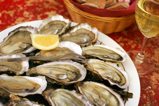 Oysters served on the weekends at the wine bar Le Baron Rouge in Paris. A perfect example of a symbiotic business relationship, oyster farmer Bernard Delis arrives every weekend from November to April with a truckload of his oysters from the Bay of Arcachon, near Bordeaux. He opens them outside the bar and they are served a traditional way, with lemon and bread and butter. The bar is always jammed with plates of oysters on every conceivable surface, including the hoods, trunks, and roofs of parked cars (© Owen Franken).