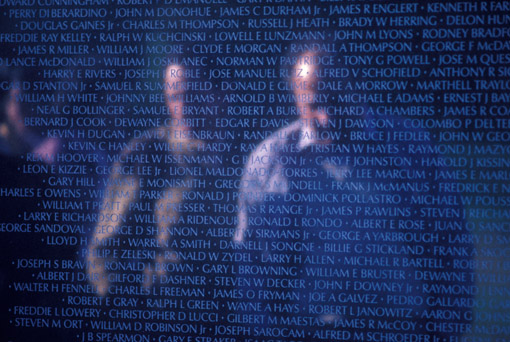 Reflection of family members at the Vietnam War Memeorial, Washington, DC (© Owen Franken).