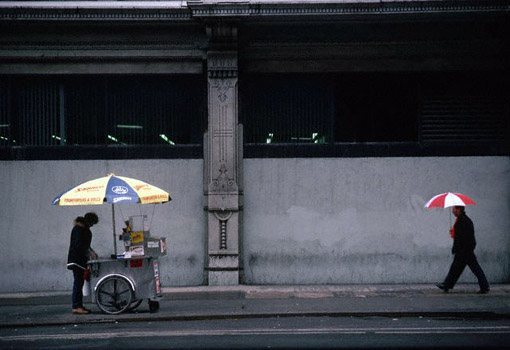 A New York City vendor tries to sell hot dogs on a cold rainy street, 1986 (© Owen Franken).