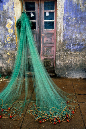 Fishing net drying outside, Praia de Ancora, Portugal (© Owen Franken/CORBIS).