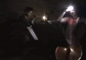 Student cellist dons miner's light to play during a temporary power loss in the MIT area.