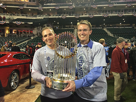 John Williams SM ’08 (right) and colleague Mike Groopman pose with the 2015 Commissioner's Trophy after the Kansas City Royals won baseball's World Series.