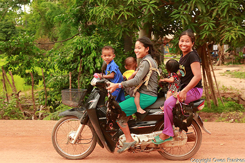 Five up and carrying dinner, on a motor cycle near Siem Reap, Cambodia (© Owen Franken).
