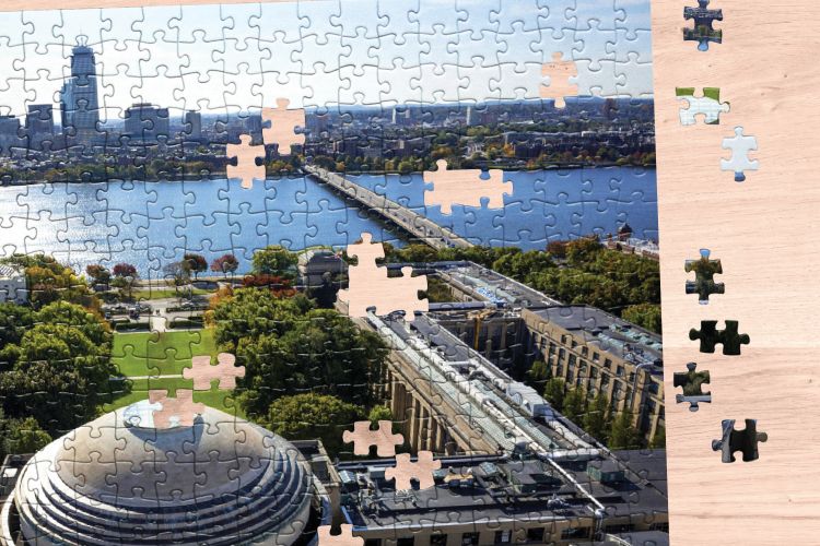 Photo of a partially completed puzzle featuring an aerial photo of Killian Court overlooking the Charles River.