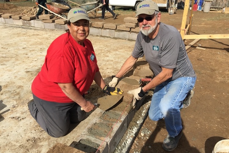 Joseph Fields and his wife, Alma, in Taos, New Mexico, laying the first course of adobe atop a cement block footer