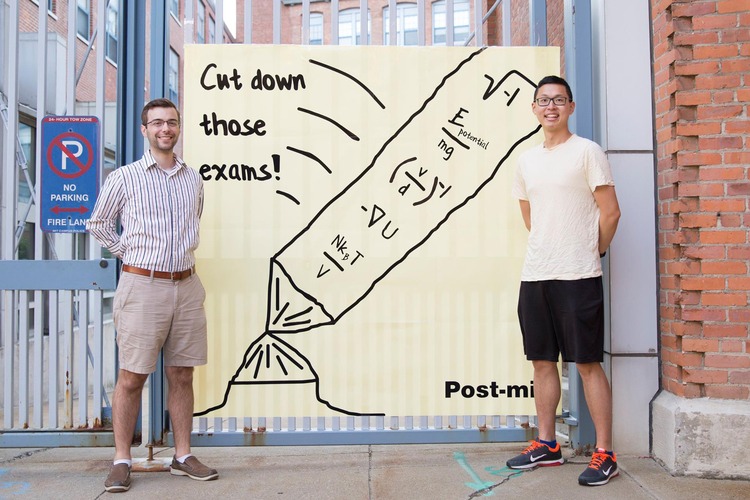 Two students standing with giant post-it note
