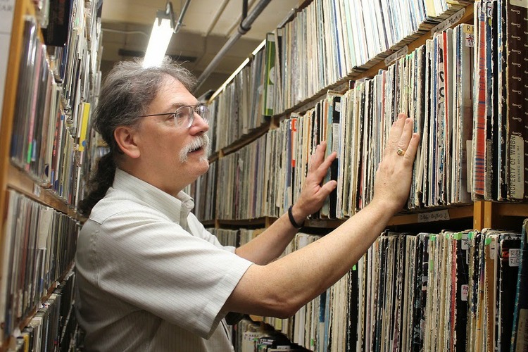 VJ at MIT's WMBR radio station looks though records 