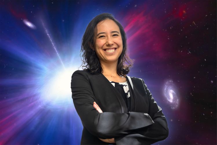 Anna Ho is shown from the waist up, arms crossed, in front of a background of stars, purple and blue, and a bright white light.