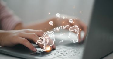 Photo illustration shows hands on a keyboard overlaid with a drawing of two heads, arrows, and the words "CHAT GPT."