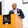 A photo of R. Robert Wickham standing at a podium with a sign that says ALC on the podium