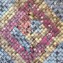 A huge number of squares of different colors are arrayed into a pattern of large diamonds in pink, yellow and blue.
