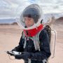 Barbara Braun is shown wearing a bubble-type helmet, a backpack, and a black flight suit. She is holding a controller.