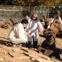 MIT alum Louise Jandura in an all white suit talking to a colleague on a rocky service with a rover/machine