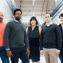 From left, Naveen Rao, Michael Carbin, Julie Shin Choi, Jonathan Frankle, and Hanlin Tang pose in a hallway.