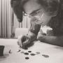 Closeup of a man leaning over a table with an array of winks. He appears to be concentrating on a shot.