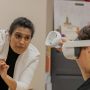 Anurupa Ganguly gestures while helping a student wearing VR goggles.